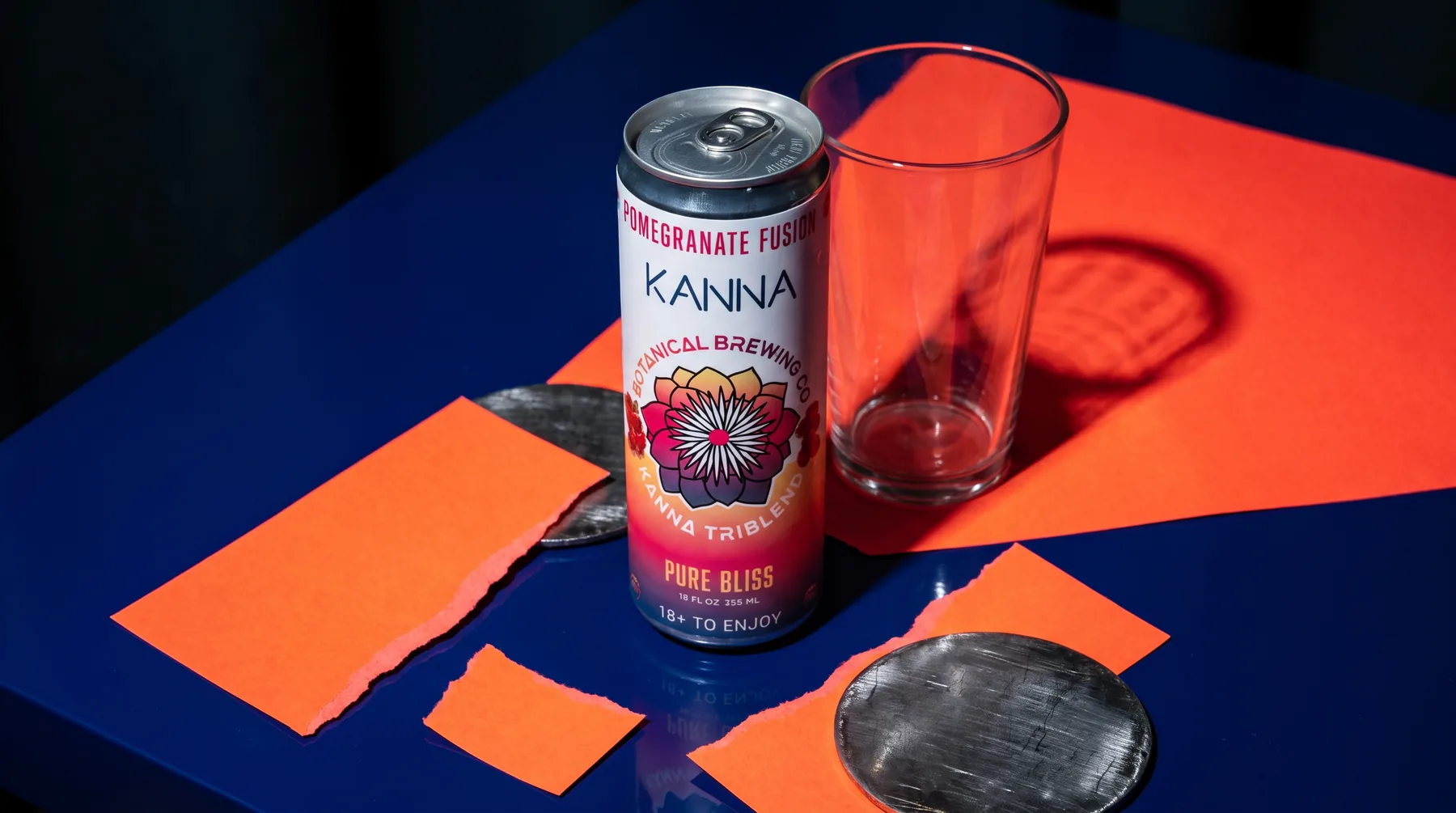 A can of Kanna Pomegranate Fusion on a dinner table with an empty glass